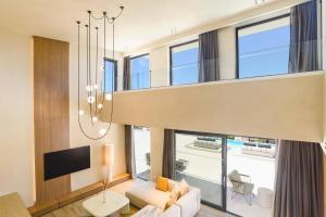 a large living room with a chandelier at Villa Pefkos Cove by Villa Plus in Pefki Rhodes