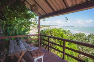 a table on a deck with a view of the ocean at Escape byBeck in Pipa
