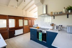 a kitchen with blue cabinets and a stove top oven at Windy Ridge in Pagham