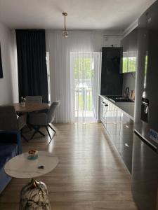 a living room with a table and a kitchen with a tableablish at Sfara Residence Apartament 6 in Baia Mare