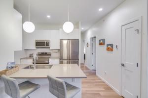 a kitchen with white cabinets and a kitchen island with chairs at Mountain Retreat in Fraser with Garage and Deck! in Fraser