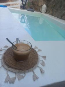 a cup of coffee sitting on a table next to a swimming pool at Cal Hidalgo in Palouet
