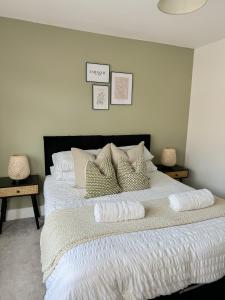 Un dormitorio con una cama grande con sábanas y almohadas blancas. en Warner Brothers House, en Watford