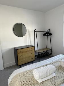 Un dormitorio con una cama con espejo y una cómoda. en Warner Brothers House, en Watford 17 fotos más
