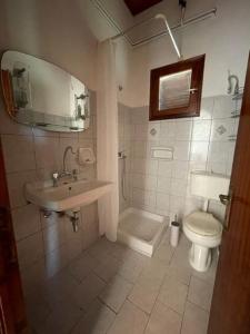 a bathroom with a sink and a toilet and a mirror at Elvira Apartments in Roda +32 photos