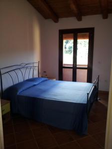 a blue bed in a room with a window at Residence Orizzonti 34 in Golfo Aranci