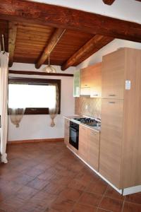 a kitchen with wooden cabinets and a stove top oven at Residence Orizzonti 34 in Golfo Aranci