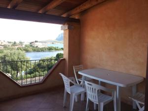 a table and chairs on a balcony with a view of a river at Residence Orizzonti 34 in Golfo Aranci +3 photos