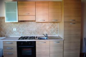 a kitchen with wooden cabinets and a sink at Residence Orizzonti 34 in Golfo Aranci