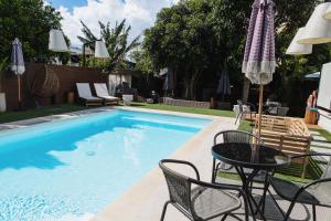 a swimming pool with a table and chairs next to it at Barneys B&b in Cercola