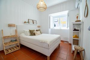 een witte slaapkamer met een bed en een raam bij Guadiana River Apartment in Vila Real de Santo António