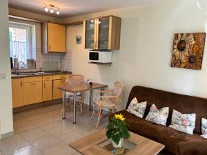 a living room and kitchen with a couch and a table at Modernes 5-Sterne-Ferienhaus im Maisonettenstil in DAMP in Damp +8 photos