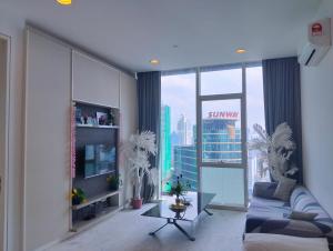 a living room with a blue couch and a large window at Bintang Lux Service Suites Platinum KLcc in Kuala Lumpur