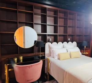 a bedroom with a bed with a desk and a mirror at Casa Maramar in Angra do Heroísmo