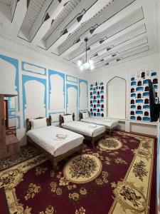 a large room with two beds and a rug at Ravshan Guest house in Bukhara