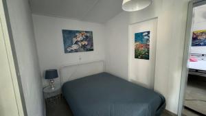 a small room with a bed and two paintings at Kanala house in Kithnos