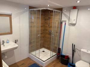 a shower with a glass door in a bathroom at Domek typu Mikołajki na Ośrodku Wędkarsko-Turystycznym Rybaczówka in Turawa