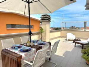 a patio with a table and an umbrella at Casa Vivì in Porto SantʼElpidio