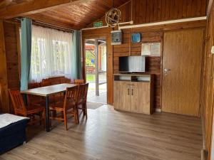 a kitchen and dining room with a table and chairs at Domek typu Mikołajki na Ośrodku Wędkarsko-Turystycznym Rybaczówka in Turawa