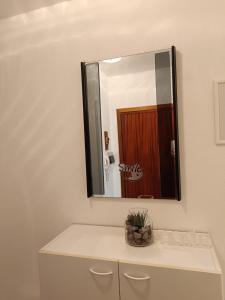 a bathroom with a mirror over a white cabinet at Appartamento Pizzo Cassandra in Chiesa in Valmalenco