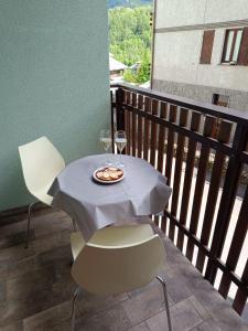 a table with a glass of wine on a balcony at Appartamento Pizzo Cassandra in Chiesa in Valmalenco +4 photos