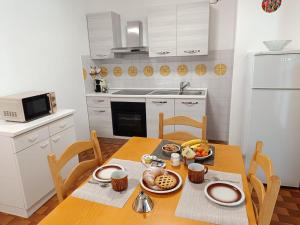 a kitchen with a wooden table with food on it at Appartamento Pizzo Cassandra in Chiesa in Valmalenco