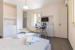 a kitchen with white cabinets and a table in a room at Appartamento Liolà in Scicli