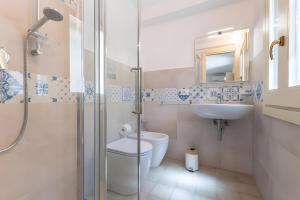 a bathroom with a shower and a toilet and a sink at Appartamento Liolà in Scicli +26 photos