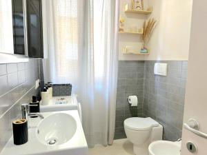 a bathroom with a white toilet and a sink at Casa Vivì in Porto SantʼElpidio