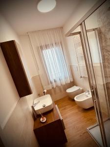 a bathroom with a sink and a toilet and a mirror at Casa AnnaPaola in Chioggia