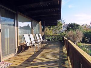 a row of white chairs sitting on a deck at Lily Pad Lake Views in Cape May Point