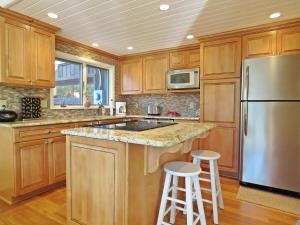 a kitchen with wooden cabinets and a stainless steel refrigerator at Lily Pad Lake Views in Cape May Point