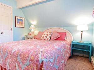 a bedroom with a pink bed with pillows on it at Lily Pad Lake Views in Cape May Point