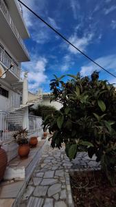 a stone walkway in front of a building with plants at Sun Oasis in Loutraki