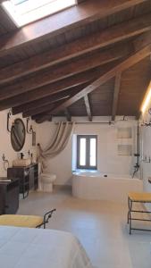 a bedroom with a bed and a tub and a sink at Casa Ypsilon Olive Oil in Sotillo de la Adrada