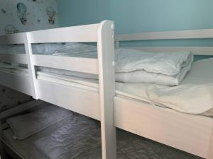a bunk bed with white bunk beds in a room at Apartments in Heiligenhafen