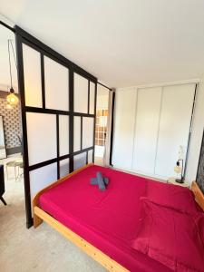 a large red bed in a room with windows at Biarritz Centre Jardin Public et Gare du Midi in Biarritz