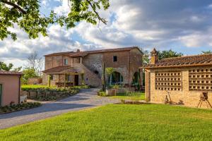 an old stone house with a grass yard at Podere Grotta Antica in Chiusi