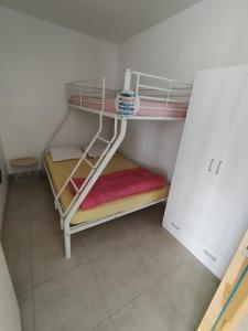 une chambre avec deux lits superposés dans une pièce dans l'établissement Maison de vacances à la plage, à Créances