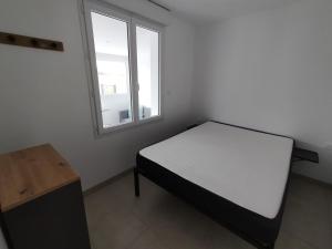 une petite chambre avec un lit et une fenêtre dans l'établissement Maison de vacances à la plage, à Créances