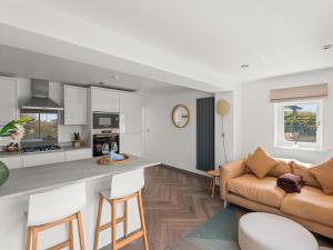 Una cocina y una sala de estar con un sofá y una mesa. en Capton Snug, en Dartmouth