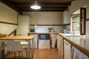 a kitchen with a table and a counter top at Alojamiento Rural Casa Roble -13802 in Güemes