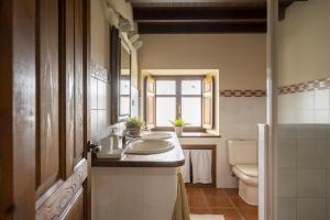 a bathroom with a sink and a toilet and a window at Alojamiento Rural Casa Roble -13802 in Güemes +52 photos