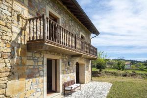 a stone building with a balcony and a bench at Alojamiento Rural Casa Roble -13802 in Güemes