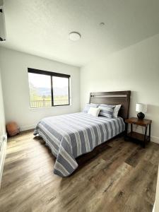 a white bedroom with a bed and a window at Spacious Accessible Ground Floor Getaway A101 in Juneau
