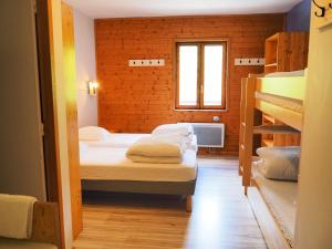 a room with two bunk beds and a window at Auberge de Jeunesse HI La Clusaz in La Clusaz