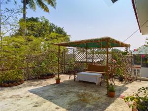 a patio with a table and a pavilion with plants at Ushas Homestay in Trivandrum