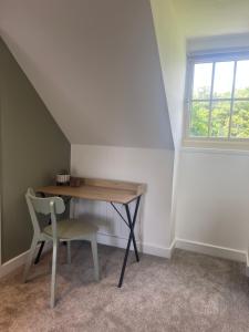 a desk and a chair in a room with a window at Woodpecker Lodge in Frampton +21 photos