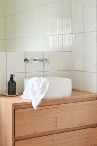 une salle de bains avec un lavabo blanc et un miroir dans l'établissement Mid-Century Modern Retreat, à Kings Park