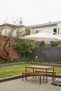 une table de pique-nique et un parasol dans une cour dans l'établissement Mid-Century Modern Retreat, à Kings Park 23 autres photos